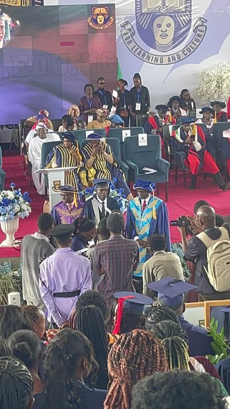 Joy on stage with university officials at the convocation